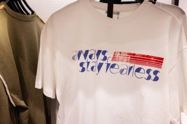 Lviv, Ukrayna - 13 Mart 2025: Perakende satış ortamında her zaman korkusuz bir mesaj içeren modern bir tişörte yakın plan.