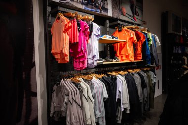 Lviv, Ukrayna - 16 Mart 2025: Canlı renklerle dolu bir perakende mağazasında düzgün bir şekilde asılı duran Zırhlı Giysiler Altındaki Spor Çeşitliliği