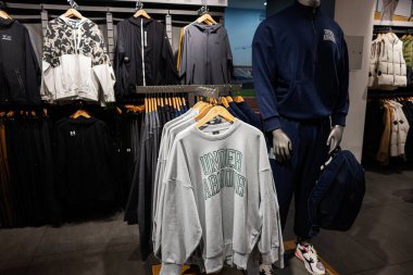 Lviv, Ukrayna - 16 Mart 2025: Askılarda ve mağazada çeşitli modern Under Armour spor kıyafetleri sergilendi.
