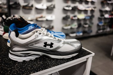 Lviv, Ukrayna - 16 Mart 2025: Arka planda çeşitli modellerin bulunduğu bir mağaza rafında Under Armour 'un koşu ayakkabılarının kapatılması