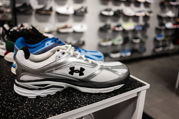 Lviv, Ukraine - March 16, 2025: Closeup of Under Armour running shoes on a store shelf with various models in background