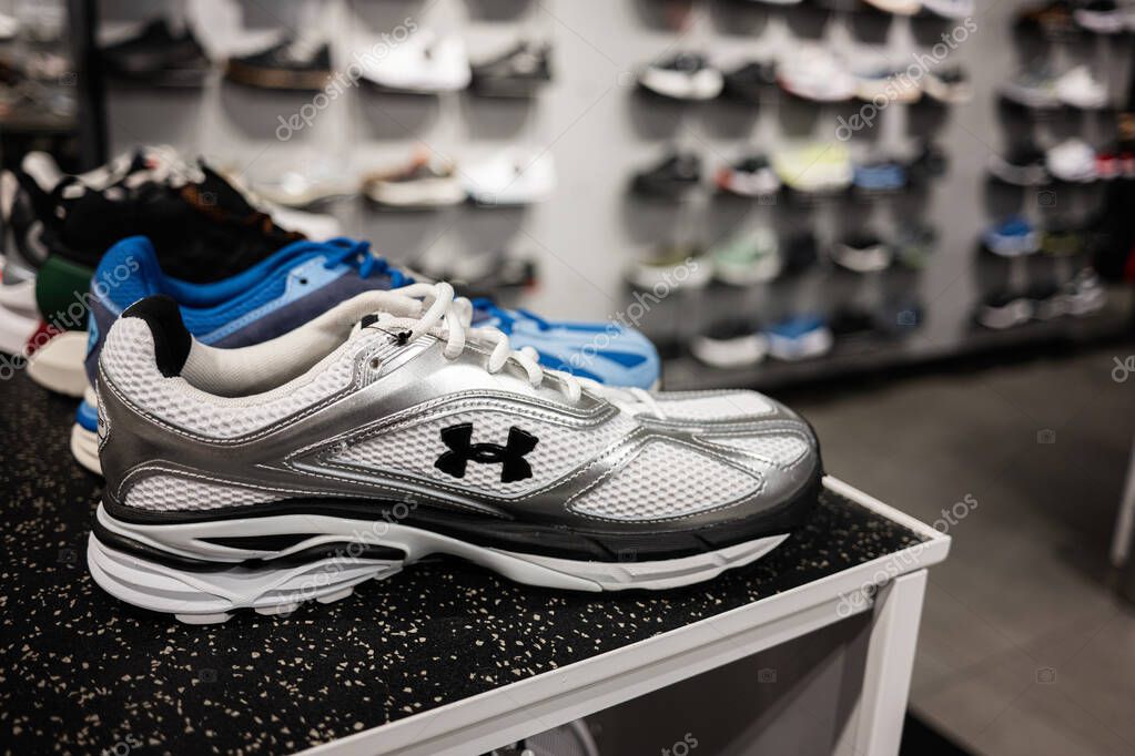 Lviv, Ukraine - March 16, 2025: Closeup of Under Armour running shoes on a store shelf with various models in background