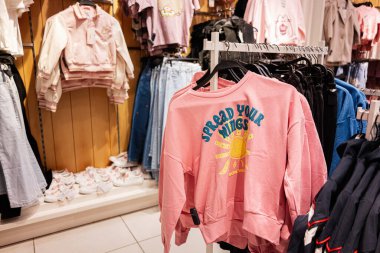 Lviv, Ukrayna - 16 Mart 2025: Kanatlarını aç. Perakende mağazasında giysi rafları parlak günlük giysiler ve giyim tasarımı sergiliyor.