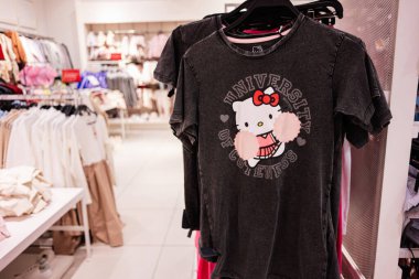 Lviv, Ukrayna - 16 Mart 2025: Parlak modern bir giyim mağazasında sergilenen yaratıcı Hello Kitty karikatür grafik tişörtü.