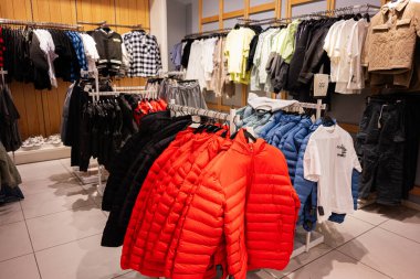 Lviv, Ukrayna - 16 Mart 2025: Modern bir giyim mağazasının raflarında çeşitli ceket ve giysiler sergilendi