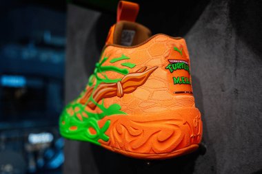 Lviv, Ukrayna - 17 Mart 2025: Turuncu ve yeşil Mutant Ninja Kaplumbağa Puma spor ayakkabıları, canlı tasarım ve estetik sergileniyor