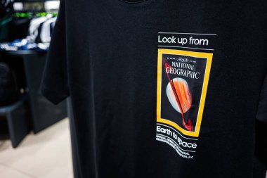 Lviv, Ukrayna - 17 Mart 2025: Ulusal Geografik tasarımı olan bir uzay temalı siyah tişört perakende ortamında sergilendi.