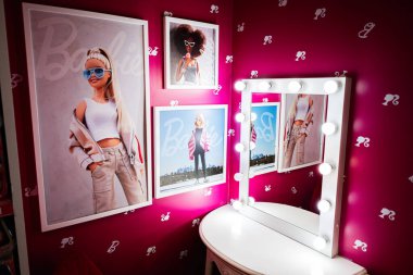 Lviv, Ukrayna - 19 Mart 2025: Pembe duvarlarında moda posterleri ve yanan bir makyaj aynası olan şık bir Barbie odası