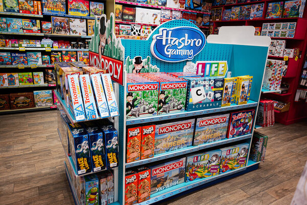 Lviv, Ukraine - March 19, 2025: Collection of famous Hasbro Gaming board games neatly arranged on shelves in vibrant toy store.