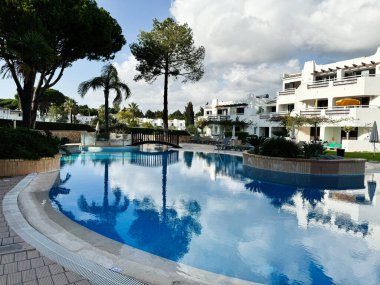 Albufeira, Portekiz - 19 Haziran 2024: Balaia Golf Köyü Tatil Köyü 'nde havuzlu lüks otel, Albufeira, Portekiz rahatlama ve modern mimariyi yansıtıyor