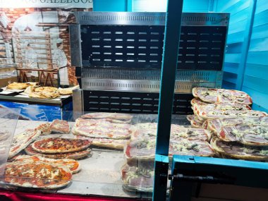 Vigo, İspanya - 31 Aralık 2024: İspanyol pazarında çeşitli malzemelerle süslenmiş pizzalar. Vigo, İspanya