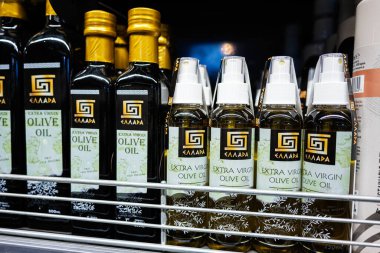 Lviv, Ukrayna - 25 Mart 2025: Ellada marka ekstra saf zeytinyağı şişeleri perakende satış mağazası rafında düzenlendi
