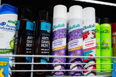 Lviv, Ukrayna - 25 Mart 2025: Bir rafta farklı marka ve tiplerde şampuanlar ve kuru şampuanlar.
