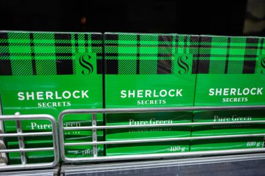 Lviv, Ukrayna - 25 Mart 2025: Cesur marka ve ekose dekoru içeren yeşil Sherlock Sırları çay paketleri.