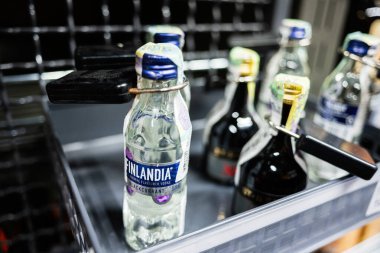 Lviv, Ukrayna - 25 Mart 2025: Finlandiya votkası ve diğer şişelerin güvenli bir şekilde rafa konması