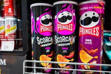 Lviv, Ukrayna - 25 Mart 2025: Pringles Scorchin 'BBQ cipsleri bir süpermarket rafındaki aperatifler arasında düzenlendi