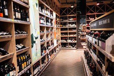 Lviv, Ukrayna - 25 Mart 2025: Ahşap raflarda çeşitli şişeleri gösteren bir süpermarketin şarap bölümü