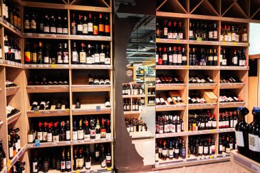 Lviv, Ukrayna - 25 Mart 2025: Parlak bir mağazadaki ahşap raflarda düzenlenmiş çeşitli şaraplar