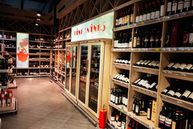 Lviv, Ukrayna - 25 Mart 2025: Organize ahşap raflarda çeşitli şarap seçimlerini ön plana çıkaran bir perakende alan.