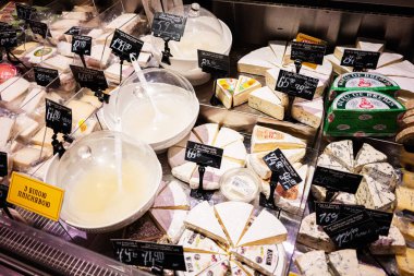 Lviv, Ukrayna - 25 Mart 2025: Dondurulmuş tezgahta sergilenen renkli peynir ve süt ürünleri çeşidi