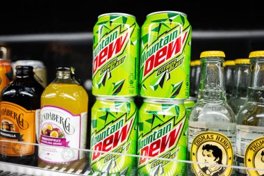 Lviv, Ukrayna - 25 Mart 2025: Aydınlatılmış bir soğutma vitrininde sergilenen çeşitli içecek kutuları ve şişeleri.