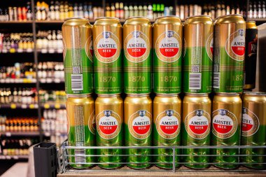 Lviv, Ukrayna - 25 Mart 2025: Amstel bira kutuları bulanık raflara karşı düzgün bir vitrinde düzenlendi