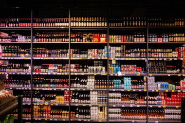 Lviv, Ukrayna - 25 Mart 2025: Renkli ambalajlarda çeşitli zanaat bira ve içeceklerle dolu süpermarket rafları