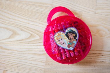 Lviv, Ukrayna - 25 Mart 2025 Ahşap zemin üzerinde prenses çizimleri olan canlı pembe plastik bir kap