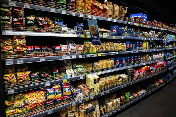 Lviv, Ukrayna - 25 Mart 2025: Reeva, Barilla makarnası ve çeşitli diğer markaların yer aldığı tam stoklanmış market rafı