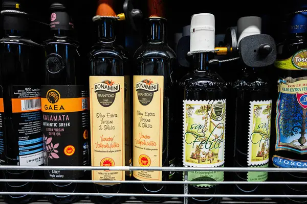 Lviv, Ukrayna - 25 Mart 2025: Çeşitli markaların sergilendiği bir mağaza rafında çeşitli zeytinyağı şişeleri.