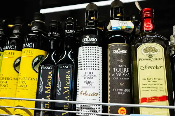 Lviv, Ukrayna - 25 Mart 2025: Perakende satışta kaliteli zeytinyağı şişeleri, canlı ürün etiketleri
