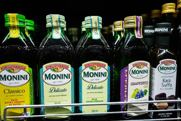 Lviv, Ukrayna - 25 Mart 2025: Çeşitli Monini ekstra bakiresi ve perakende satışta bulunan zeytinyağı şişeleri.