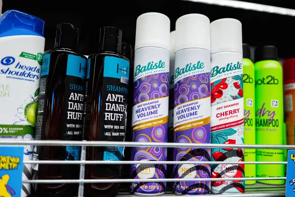 Lviv, Ukrayna - 25 Mart 2025: Bir rafta farklı marka ve tiplerde şampuanlar ve kuru şampuanlar.