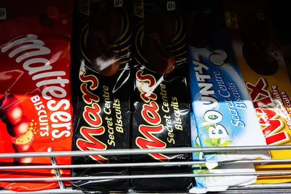 Lviv, Ukrayna - 25 Mart 2025: Parlak ambalajlarda çeşitli Malteserler, Mars, Bounty ve Twix bisküvi paketleri sergilendi