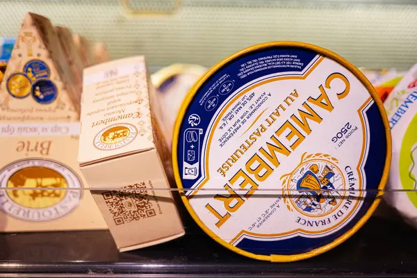 Lviv, Ukrayna - 25 Mart 2025: Marka ambalaj içeren bir market soğutma bölümünde Camembert peynirinin yakın çekimi