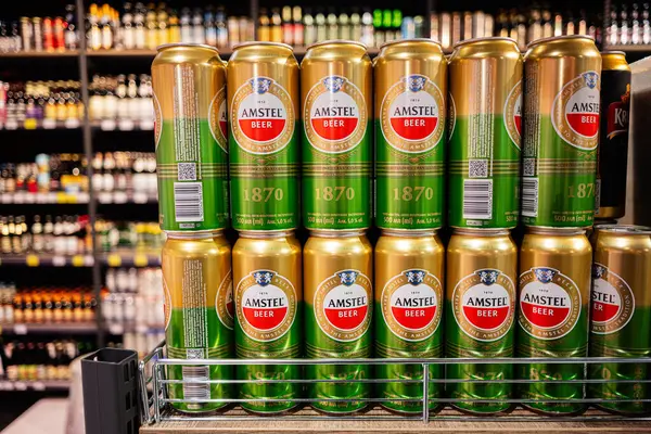 Lviv, Ukrayna - 25 Mart 2025: Amstel bira kutuları bulanık raflara karşı düzgün bir vitrinde düzenlendi