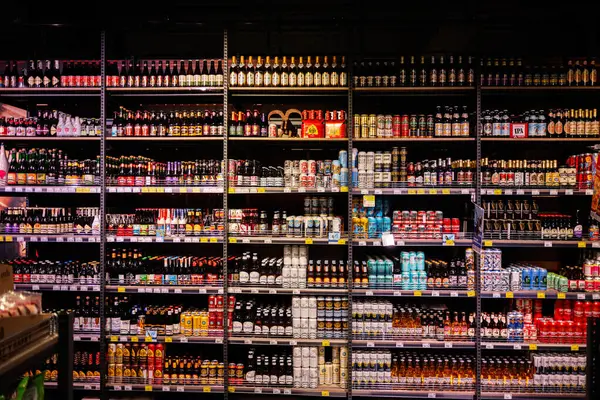 Lviv, Ukrayna - 25 Mart 2025: Renkli ambalajlarda çeşitli zanaat bira ve içeceklerle dolu süpermarket rafları