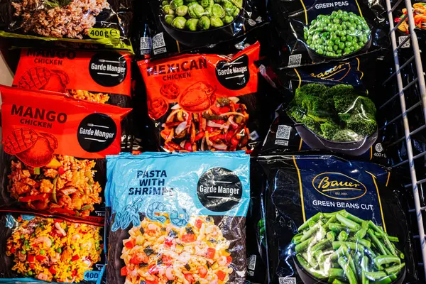 Lviv, Ukrayna - 25 Mart 2025: Donmuş gıda ürünleri farklı yemek ve sebzeleri gösteren renkli ambalajlarda sergileniyor
