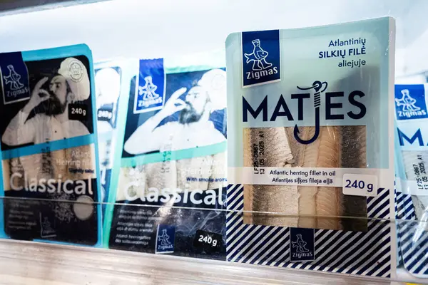 Lviv, Ukrayna - 25 Mart 2025: Paketlenmiş Zigmas Atlantik ringa ürünleri bir marketin buzdolabı bölümünde sergilenmektedir.