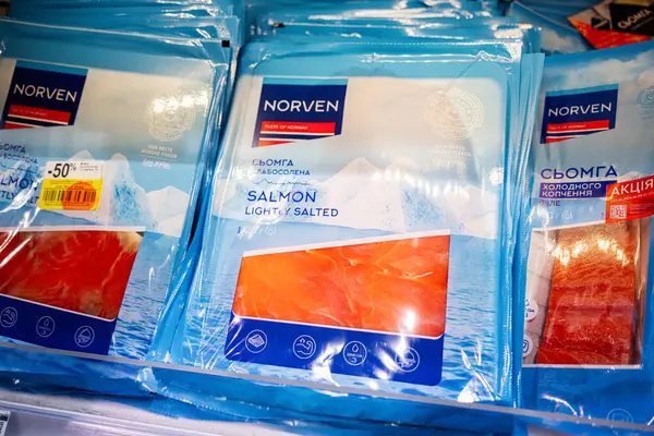 Lviv, Ukrayna - 25 Mart 2025: Bir süpermarketin soğutulmuş vitrininde düzgünce düzenlenmiş Norven marka somon filetoları.