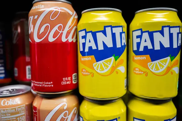 Lviv, Ukrayna - 25 Mart 2025: Renkli Coca-Cola Vanilya ve Fanta Limonlu soda kutuları.
