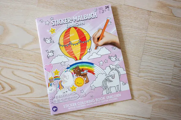 Lviv, Ukrayna - 25 Mart 2025: Gökkuşağı temalı ve renkli resimli çocuklar için renkli tek boynuzlu at çıkartması kitabı.