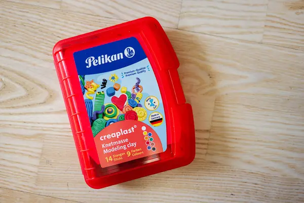 Lviv, Ukrayna - 25 Mart 2025: Pelikan 'ın Creaplast modelleme kil kırmızı bir kap, çeşitli renkli parçalar ile dolu.