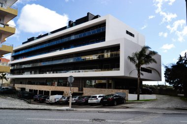 Fatima, Portekiz - 24 Mart 2025: Fatima, Portekiz 'de park yeri ve açık mavi gökyüzü bulunan çağdaş apartman