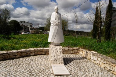 Fatima, Portekiz - 24 Mart 2025: Katolik Kilisesi 'nin Macar kardinali Mindszenty Jozsef heykeli, yeşil ve gökyüzü ile çevrili asfalt bir alanda duruyor..