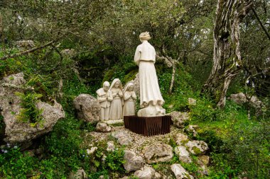 Fatima, Portekiz - 24 Mart 2025: Portekiz 'in Fatima kentindeki doğal sakin ortamda bulunan dini figürleri tasvir eden heykeller.