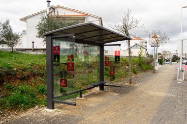 Fatima, Portekiz - 24 Mart 2025: Portekiz 'in yeşilliklerle çevrili Fatima kentindeki cam panellerle halka açık otobüs durağı.