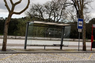 Fatima, Portekiz - 24 Mart 2025: Fatima Portekiz 'de bulutlu gökyüzünün altında ağaçlarla çevrili modern bir otobüs durağı