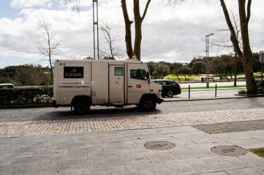 Fatima, Portekiz - 24 Mart 2025: Beyaz nakit nakliye kamyonu Loomis Portekiz 'in Fatima kentinde asfalt sokak ve ağaçların yakınında yakalandı.