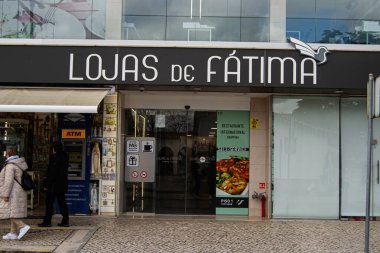 Fatima, Portekiz - 24 Mart 2025: Lojas de Fatima 'da müşterileri ve tabelaları gösteren hareketli bir giriş.